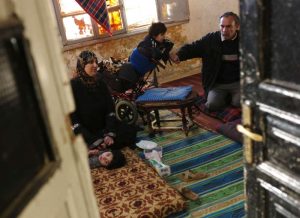 Mohammed and his family gather on the floor of their dilapidated apartment in downtown Amman. Two of his children are living with disability. The family receive 100 Jordanian dinars (US$140) a month in cash assistance from UNHCR, but after paying for electricity and gas they rely entirely on vouchers from the World Food Programme to cover all their other expenses. © UNHCR/B.Szandelszky